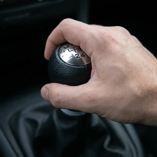 Pommeau de vitesse simili-cuir C4 tenu en main sur le levier de vitesses