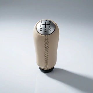 Pommeau de vitesse Clio 3 beige, vue de face sur fond neutre