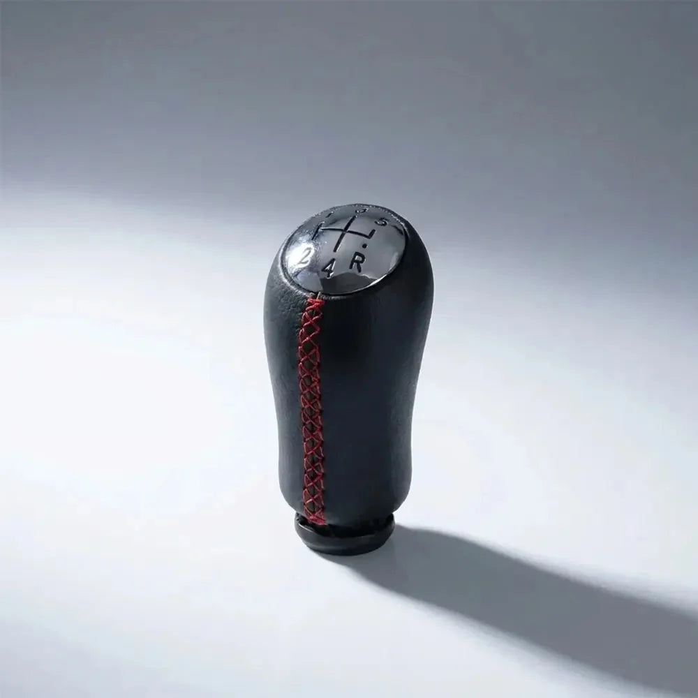 Pommeau de vitesse Mégane 2 couture rouge, vue produit isolée avec surpiqûres rouges apparentes et schéma des vitesses gravé