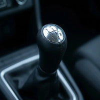 Pommeau de vitesse Scénic 2 couture noire installé sur le levier de vitesses, vue rapprochée en ambiance intérieure